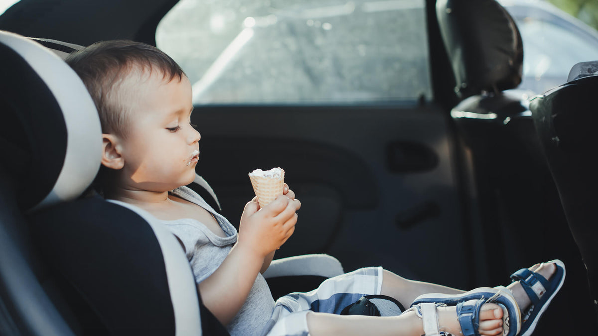 Kind kleckert mit Eis im Auto