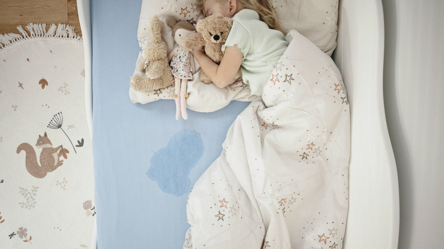 Mädchen schläft im Bett mit Urinfleck am Rand